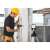 Muncitor in constructii folosind nivela laser Kapro VIP Green pe trepied