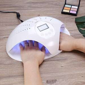 SUN 669 UV/LED nail lamp with two hands in it, curing gel polish - Nail dryer lamp