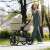 Woman walking with Petite & Mars ICON 2in1 Mocha Beige XXL RWS stroller with bassinet