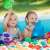 Two children playing in a pool with colorful plastic balls