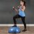 Woman exercising with Springos Bosu ball and resistance bands