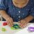 Kind benutzt Play-Doh Fold 'N' Go Spielset mit Hai-förmigem Ausstecher.
