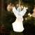 LED angel Christmas ornament, white, clear, with wings, holding a musical instrument, on a Christmas tree