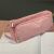Pink pencil case on a desk with notebook