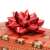Metallic red self-adhesive star bow on a gift box