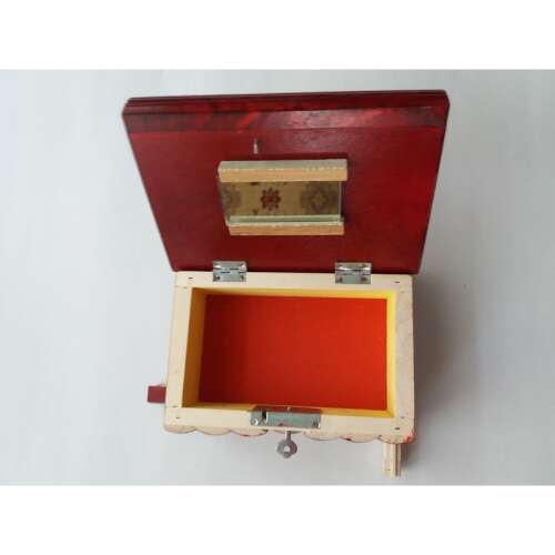 Red wooden secret box with hidden key and compartments, open to reveal the interior