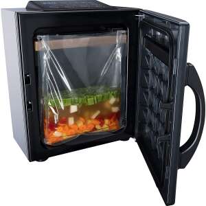 Steba KVK 50 vacuum sealer with open door, showing vegetables in a vacuum bag - Steba