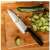 Fiskars Chef's Knife on cutting board with cucumber