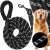Black and white rope dog leash with padded handle, dog in the background