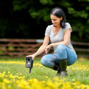 Nő Defenders Mega-Sonic rókariasztót telepít a kertben, rókariasztó használat közben - Vadriasztó