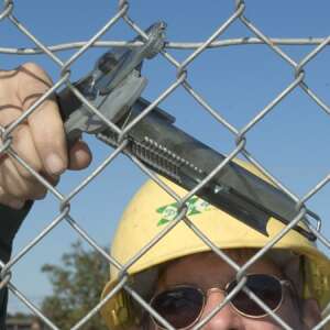 A person using fence wire pliers to install a chain link fence - Other hand tool