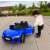 Gyermek kinyitja a kék Audi R8 Spyder elektromos kisautó ajtaját