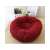 Red plush dog bed on a wooden floor