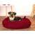 Red plush dog bed with a dog laying in it