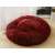 Red plush dog bed on a wooden floor