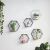 Rafturi decorative hexagonale de perete în negru și alb cu plante și figurine