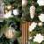 Close-up of Springos® Artificial Spruce Christmas Tree branches with white flowers and gold ornaments