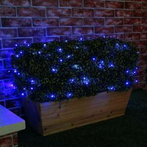 Blue Christmas lights decorating a bush - Home & Garden