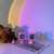 Two pink bunny shaped rainbow projector night lights casting a rainbow on the wall