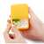 Hand holding yellow Flippy pill box with 2 compartments, filled with pills