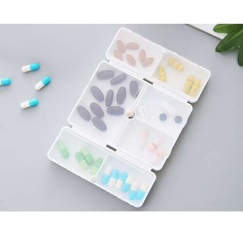 Flippy 7 compartment pill box, white and black, open, showing compartments with pills