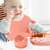 Baby using pink silicone feeding set with bib, bowl, plate, spoon and fork