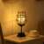 Flippy wine glass shaped LED table lamp with warm white light on a nightstand
