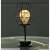 Black metal wine glass shaped LED table lamp with warm white light on a table