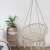 Pepita macrame hanging chair in bedroom setting, beige