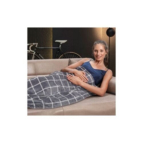 Frau entspannt mit Imetec grauer Heizdecke auf dem Sofa