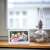 Sencor SDF 782 WH digital photo frame displaying a picture of a family, placed on a windowsill
