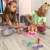 Two girls playing with Barbie styling head, blonde hair, pink top, necklace, and accessories for styling hair