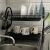 Two-tier black dish rack with dishes and mugs next to a kitchen sink