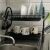 Two-tier black dish rack with dishes and mugs next to a kitchen sink