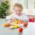 Child playing with New Classic Toys Cutting Meal wooden play food set