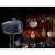 Star Shower Plug outdoor laser projector, black, with a ground stake, projecting Christmas images onto a house
