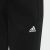 Közelkép az Adidas logóról fekete melegítőnadrágon