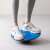 Persoană care folosește placa de echilibru albastră Navaris pentru exerciții
