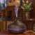 Dark wood effect ultrasonic aroma diffuser with 7 color LED light, timer, and remote control, in use