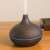 Dark wood effect ultrasonic aroma diffuser with 7 color LED light, timer, and remote control, in use