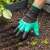 Person using the gardening gloves with claws to plant in the garden