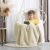 Boy sitting in a hanging chair with a beige SHLEEPY blanket