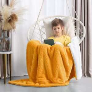 Boy wrapped in Takaro SHLEEPY orange blanket reading on a swing chair - Interior design