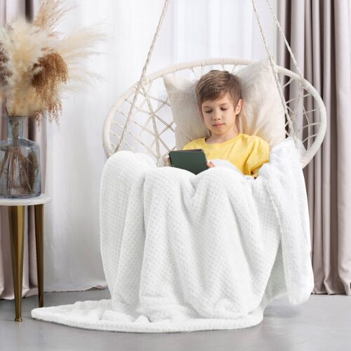 Boy wrapped in AmeliaHome SHLEEPY white blanket reading on a tablet in a hanging chair