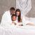 Family wrapped in AmeliaHome SHLEEPY white blanket on a bed