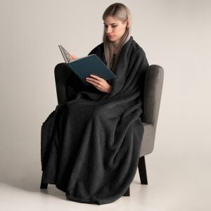 Žena číta knihu zabalená v čiernej deke DecoKing Henry - Posteľná bielizeň