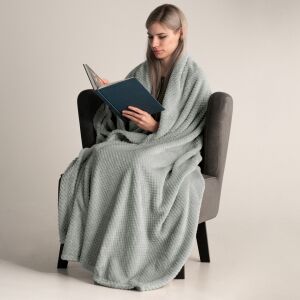 Woman wrapped in DecoKing HENRY grey blanket reading a book - Interior design