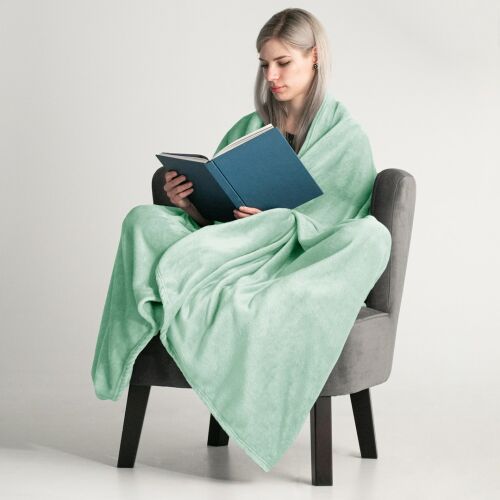 Woman wrapped in DecoKing MIC mint green microfiber blanket reading a book