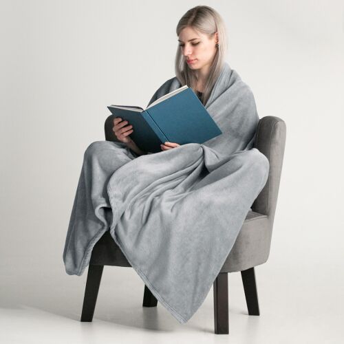 Frau liest ein Buch, eingewickelt in eine graue DecoKing MIC Decke