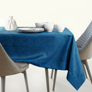 AmeliaHome Gaia indigo blue embossed tablecloth on a set table with dishes and decorations. - Decoration